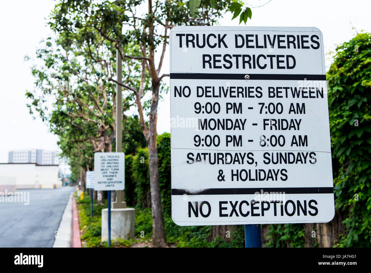 Délais de livraison camion restreint signe entre l'arrière d'un centre commercial et une zone résidentielle Banque D'Images