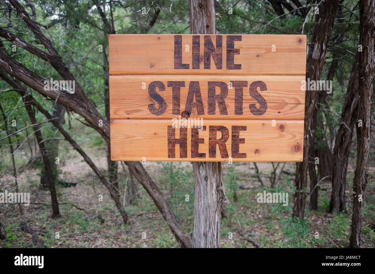 Un panneau en bois qui dit, 'Ligne commence ici." dans Wimberley, Texas Banque D'Images