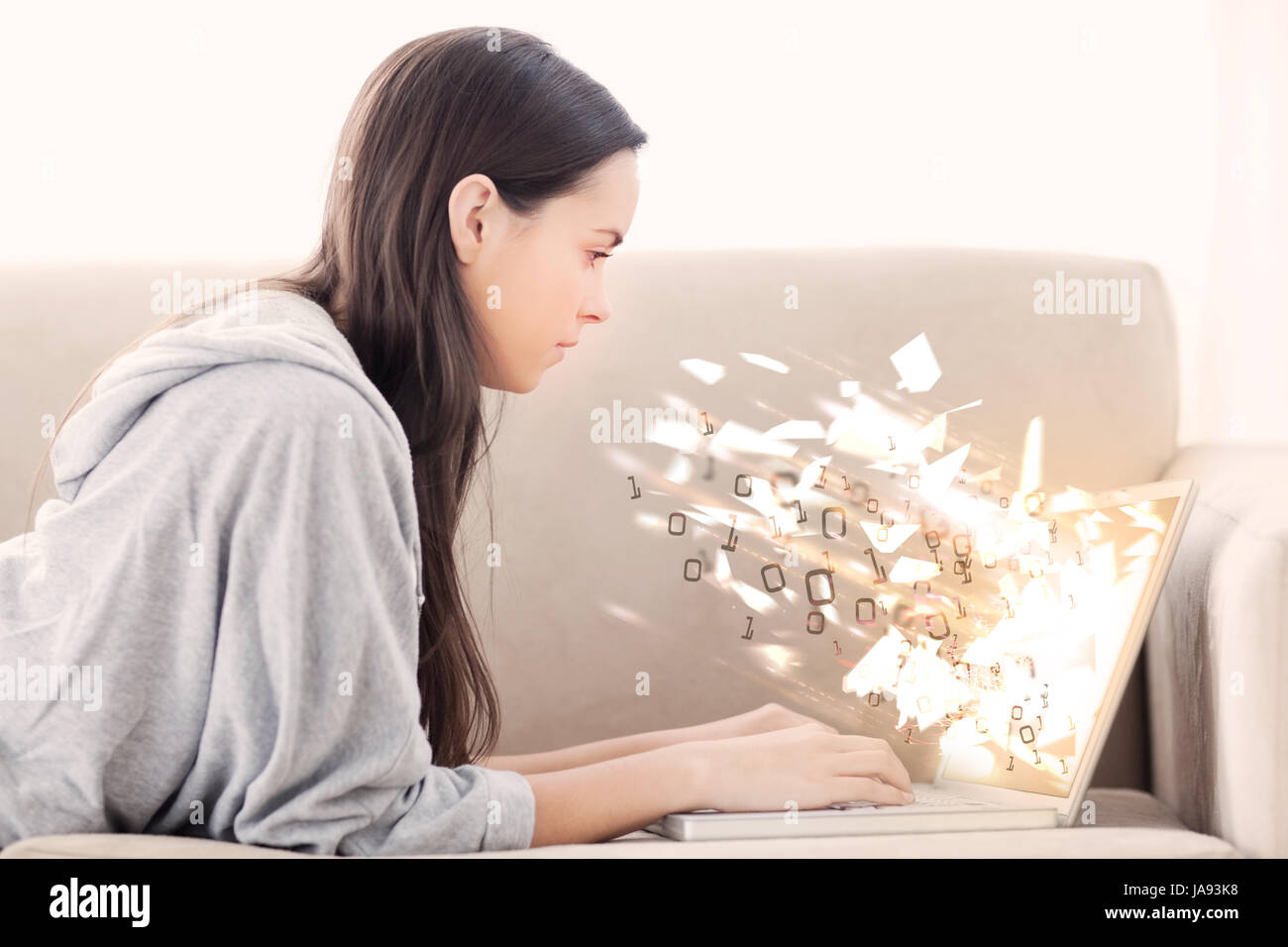 Femme sur la table à l'aide de la laptop with binary codes exploding sur Banque D'Images