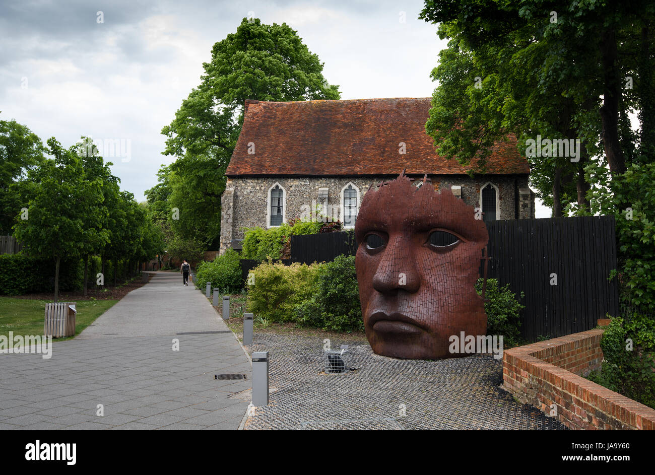 Canterbury, Kent, Angleterre - 15 mai 2017 : Le masque de visage ou une cloison art créée par Rick Kirby , sculpteur britannique assis dehors Théâtre Marlowe à th Banque D'Images