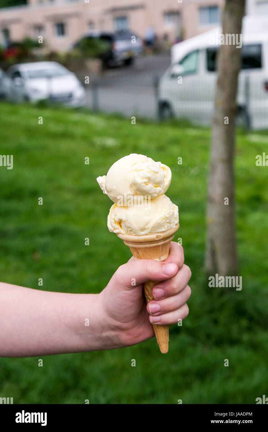 Un enfant tenant un cornet de crème glacée. Banque D'Images