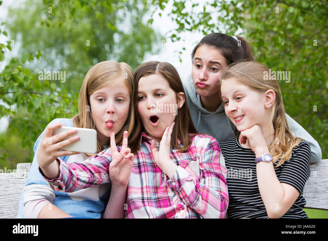 Groupe de Jeunes filles posant pour en Selfies Park Banque D'Images