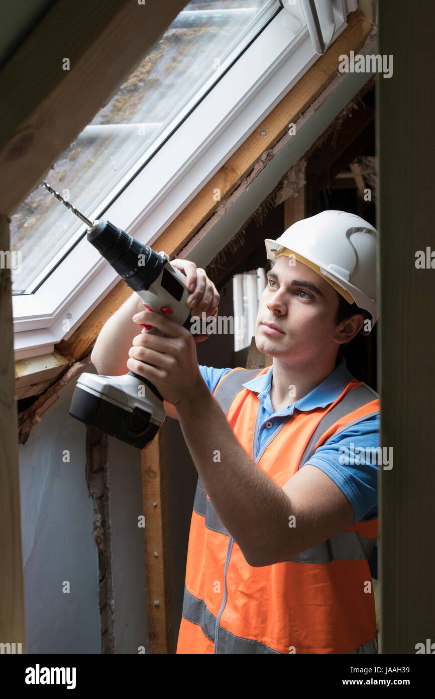 Travailleur de la construction en utilisant la mèche d'installer la fenêtre de remplacement Banque D'Images