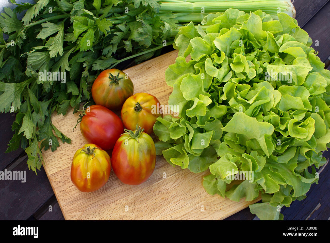 Ingrédients légumes frais pour rendre l'été parfait salade de laitue, tomates, carottes sur la table rustique, d'un éclairage naturel Banque D'Images