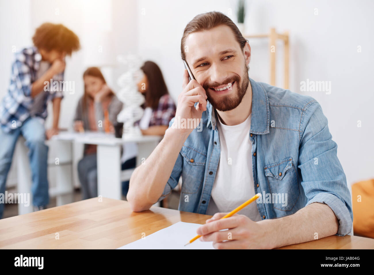 Avez-vous un moment. Beau plaisir vibrant homme assis dans la classe et