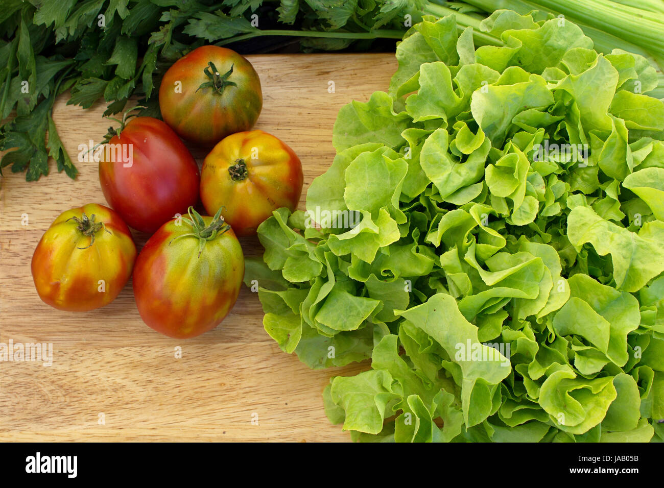 Ingrédients légumes frais pour rendre l'été parfait salade de laitue, tomates, carottes sur la table rustique, d'un éclairage naturel Banque D'Images