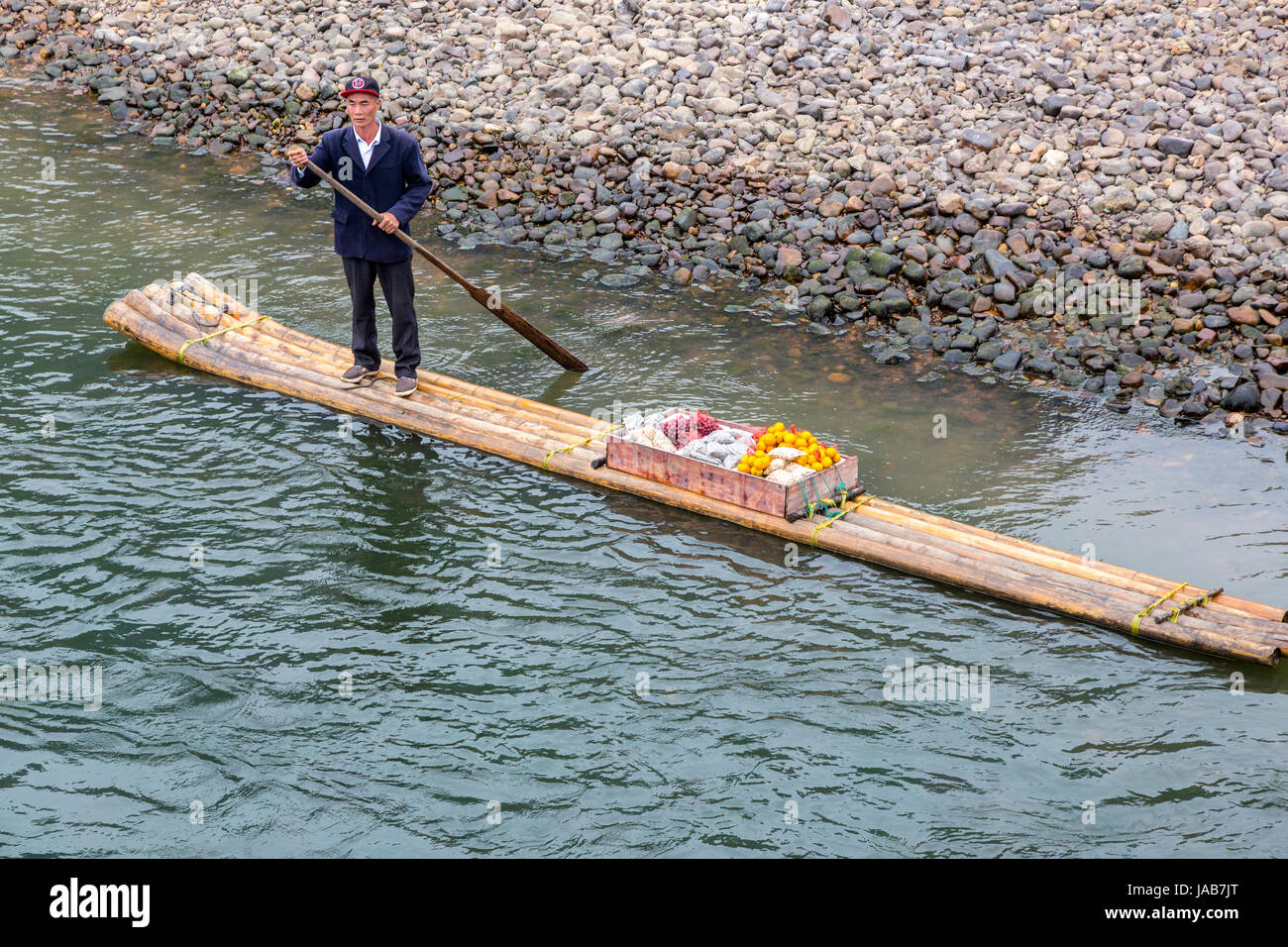 Croisière sur la rivière Li, région du Guangxi, Chine. Boatman déménagement l'approvisionnement alimentaire en amont sur un radeau en bambou. Banque D'Images