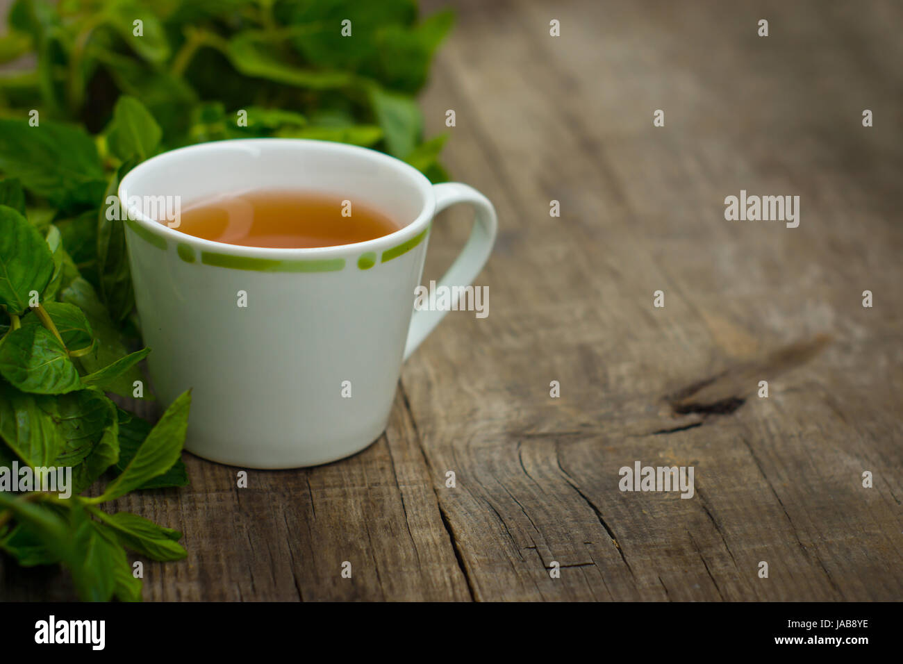 Une tasse de thé à la menthe sur fond texturé bois Banque D'Images