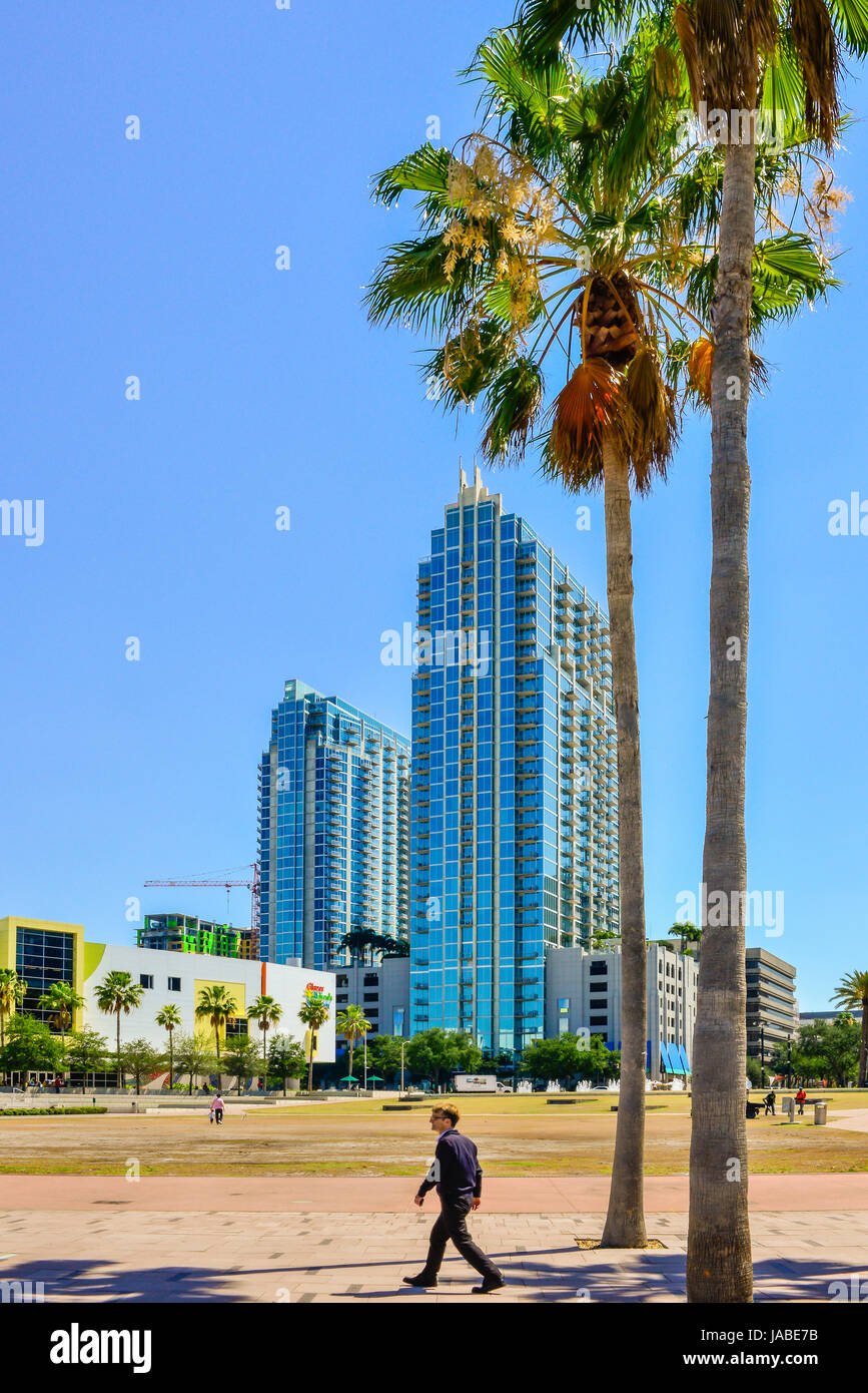 Les Glazer Children's Museum est dominé par la silhouette élégante du SkyPoint Condominium tandis que l'homme de promenades dans le parc riverain Hixon, Tampa, FL Banque D'Images