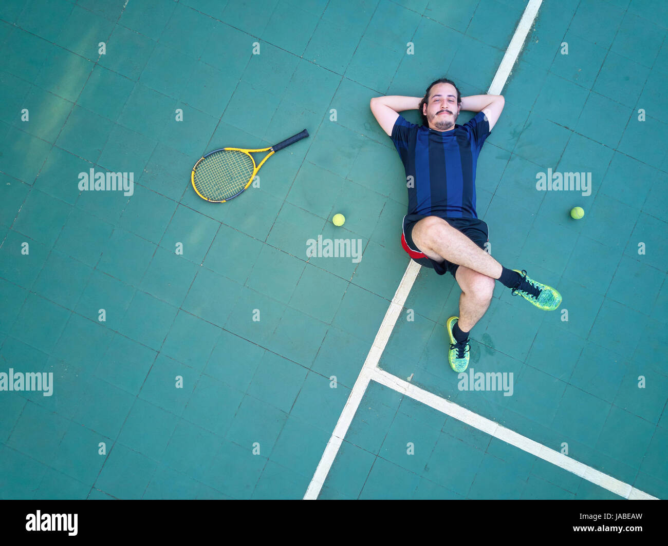 Fatigué tennis player déposer sur cour vue ci-dessus. L'homme perdre jeu de tennis Banque D'Images