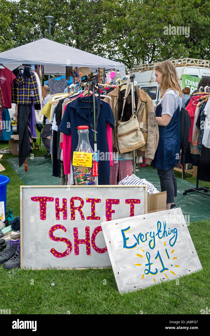 Une jeune femme en regardant à travers les racks dans un magasin d'aubaines au cours de l'openair Meadows Festival à Édimbourg. Banque D'Images