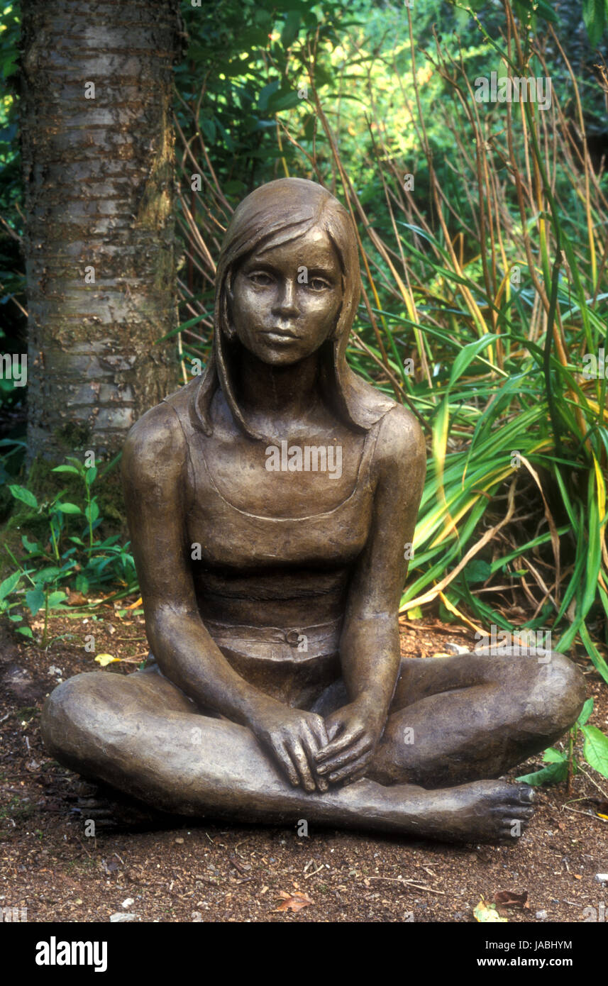 Sculpture de jardin d'une jeune fille assis jambes croisées sur le terrain, New South Wales, Australie. Banque D'Images