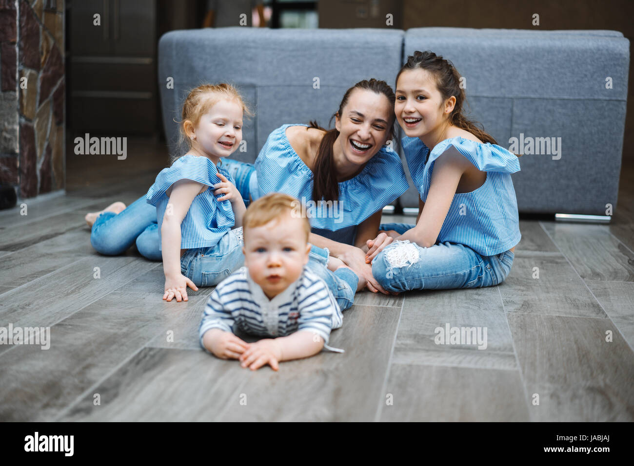 Maman, deux filles et un petit garçon sur le sol Banque D'Images
