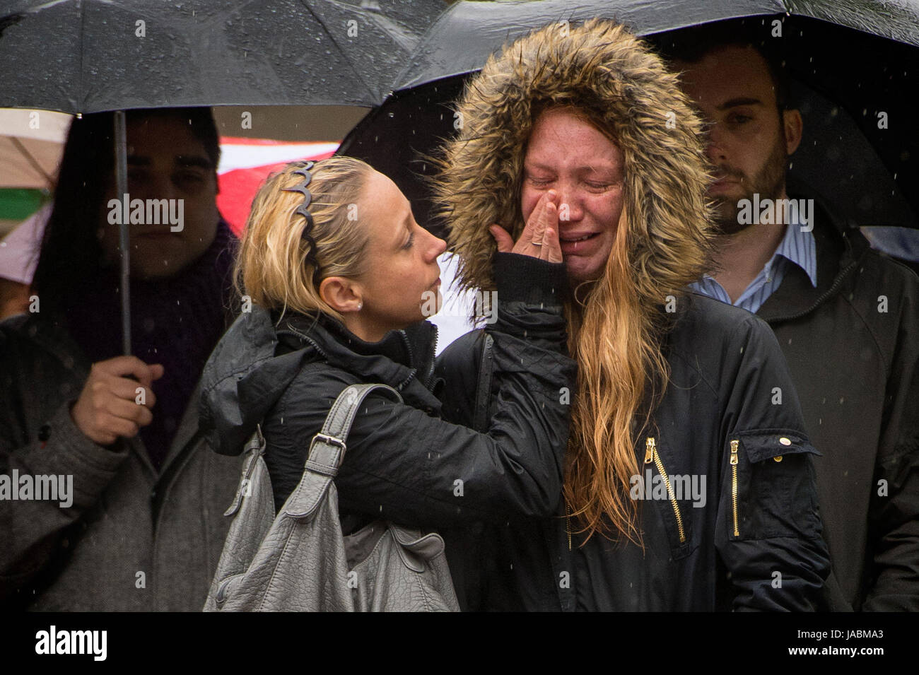Deux femmes réconforter mutuellement pendant une minute de silence sur le pont de Londres en l'honneur de l'attaque terroriste victimes décédées dans l'indignation samedi. Banque D'Images
