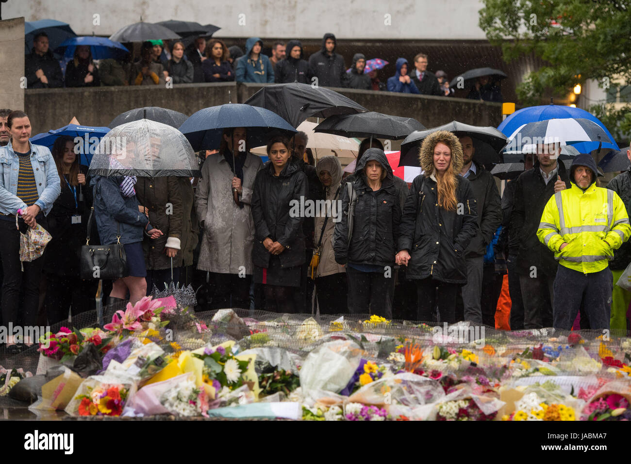Les gens à observer une minute de silence sur le pont de Londres en l'honneur de l'attaque terroriste victimes décédées dans l'indignation samedi. Banque D'Images