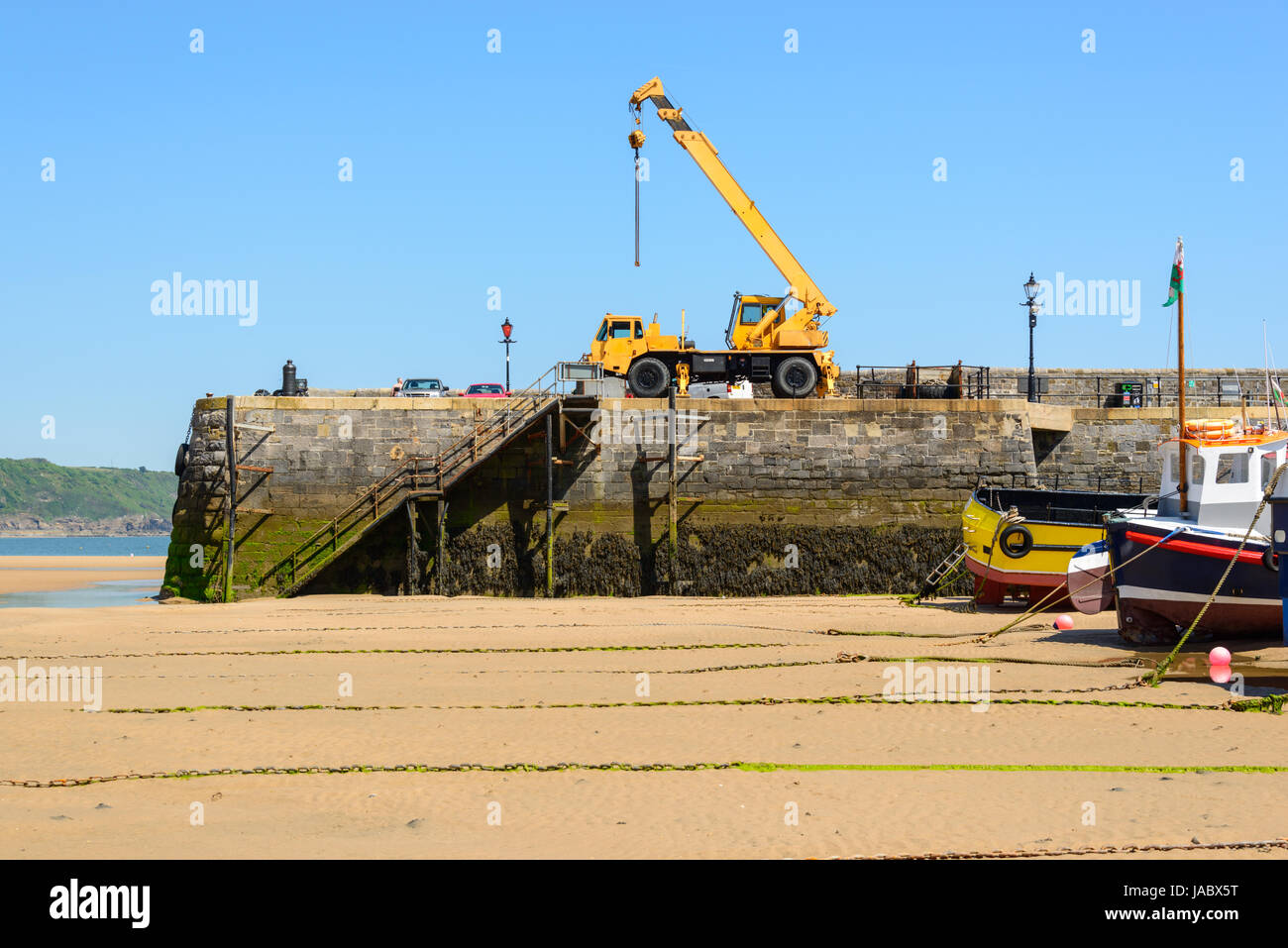 Voir l'usine de machinerie lourde sur le mur du port. Tenby. Pembrokeshire. UK. Banque D'Images