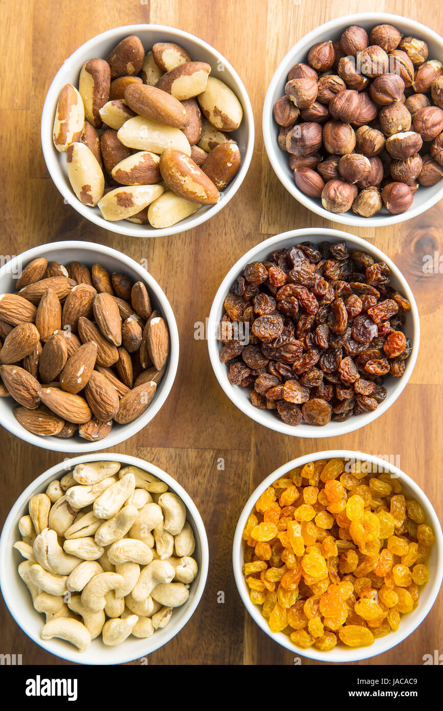 Divers Les noix et les raisins secs dans un bol sur la table en bois. Banque D'Images