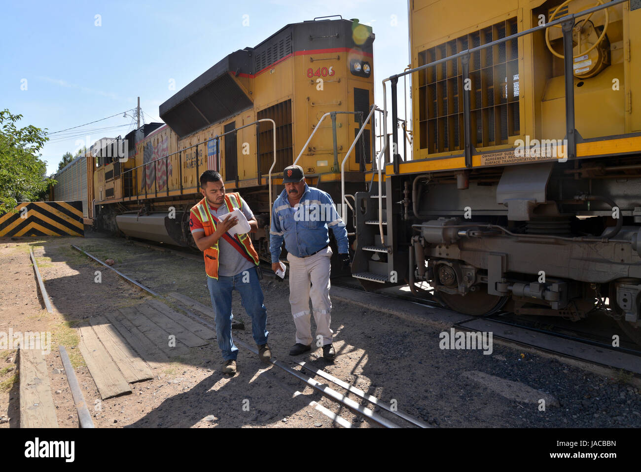 Un train transportant des voitures fabriquées dans les arrêts Nogales, Sonora, Mexique, avant d'entrer dans une barrière métallique à Nogales, Arizona, USA. Banque D'Images