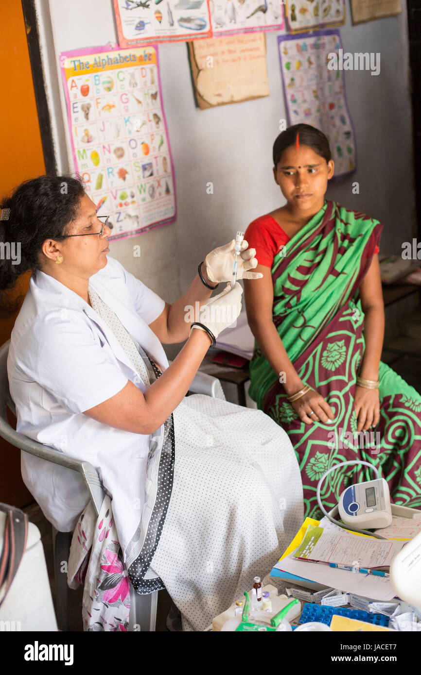 Une femme enceinte reçoit une vaccination de routine dans un centre de santé dans l'Uttar Pradesh, Inde. Banque D'Images