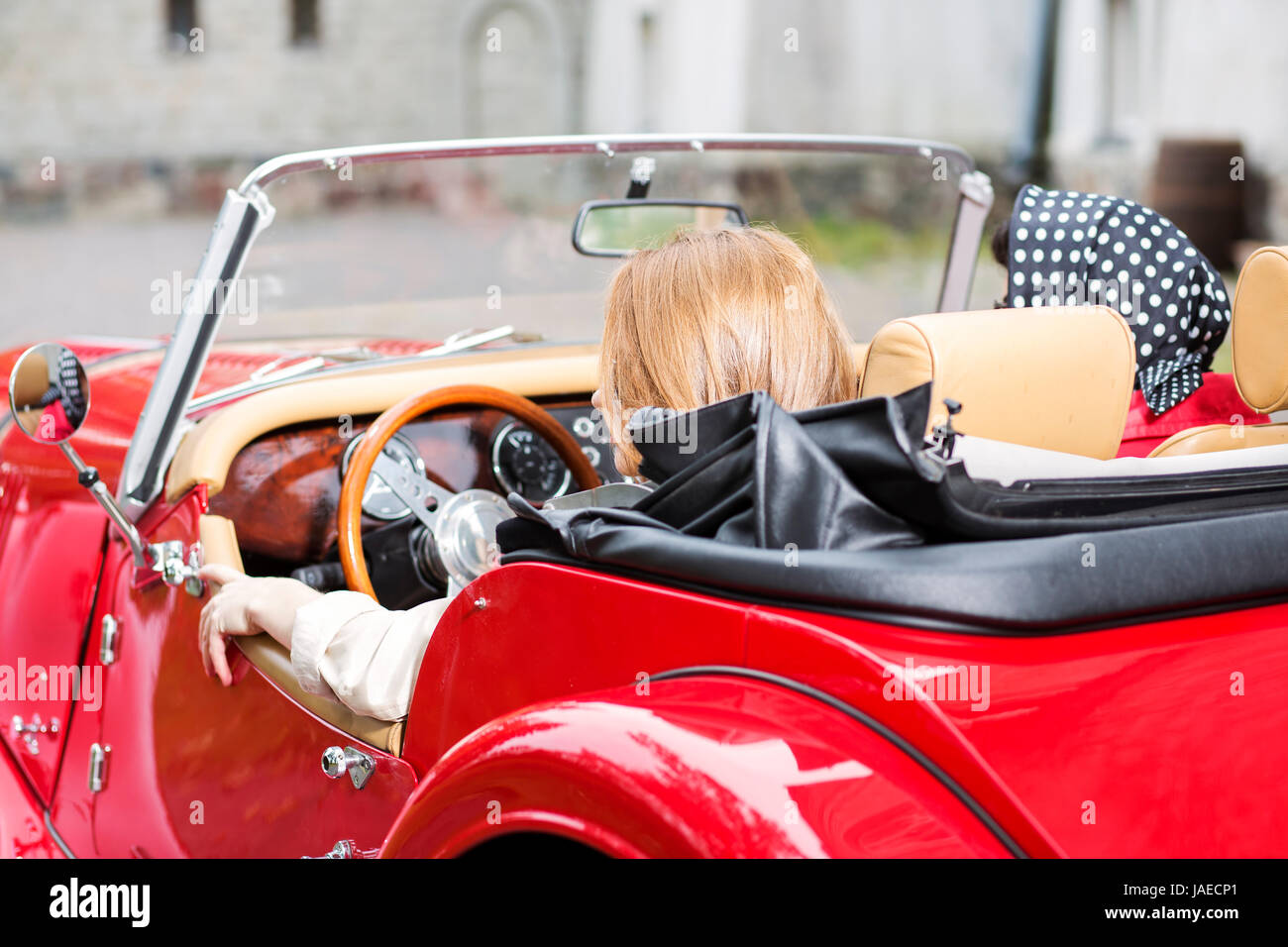 Jolies femmes à retro voiture rouge de derrière Banque D'Images