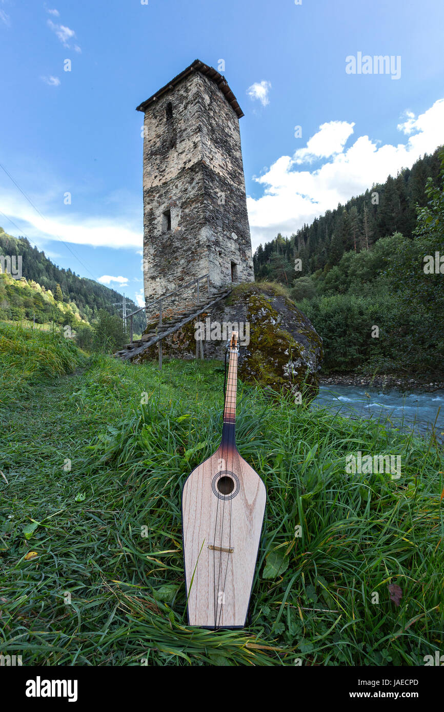 Instrument de musique nationale géorgienne de Panduri avec une tour médiévale dans l'arrière-plan, dans la région de Svaneti des montagnes du Caucase, en Géorgie. Banque D'Images