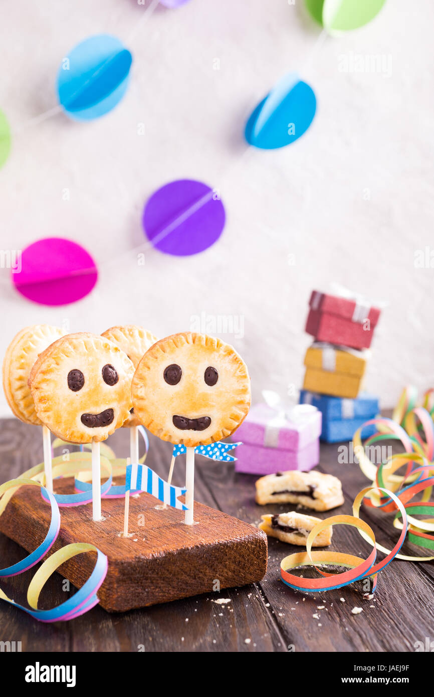 Sablés faits maison smiley cookies au chocolat noir sur stick appelé pie pop. Childrens Party background. Banque D'Images