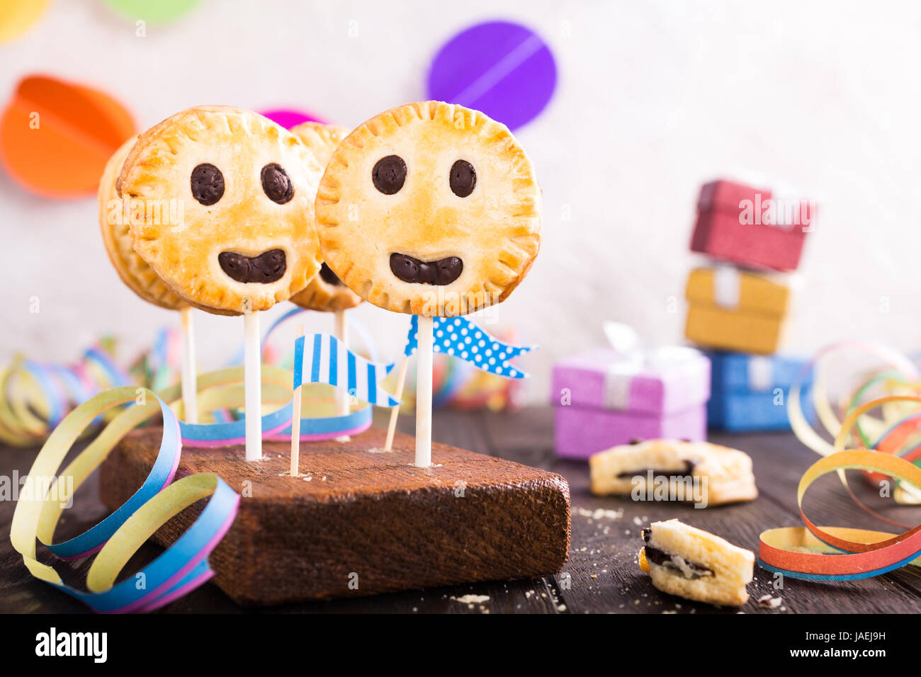 Sablés faits maison smiley cookies au chocolat noir sur stick appelé pie pop. Fête pour les enfants. Banque D'Images