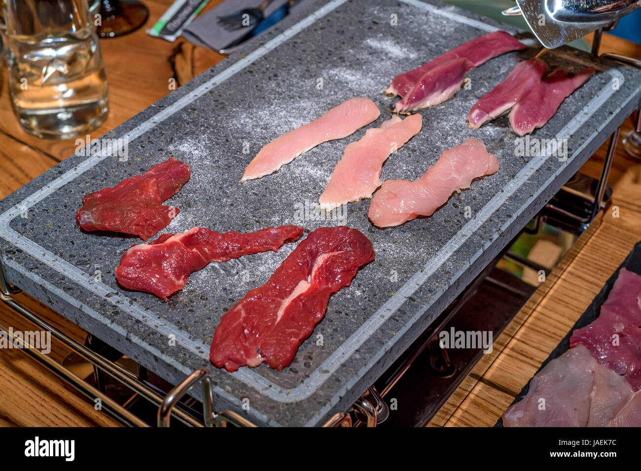 Diverses sortes de viande préparés pour la cuisson sont grillés sur ardoise graphite Banque D'Images