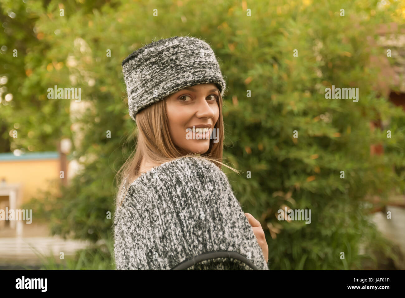 Tête et des épaules, vue latérale, arrière, un jeune adulte, Caucasian woman smiling outdoors wearing sweater et chapeau, vêtements ethniques (Europe de l'Est, se Banque D'Images