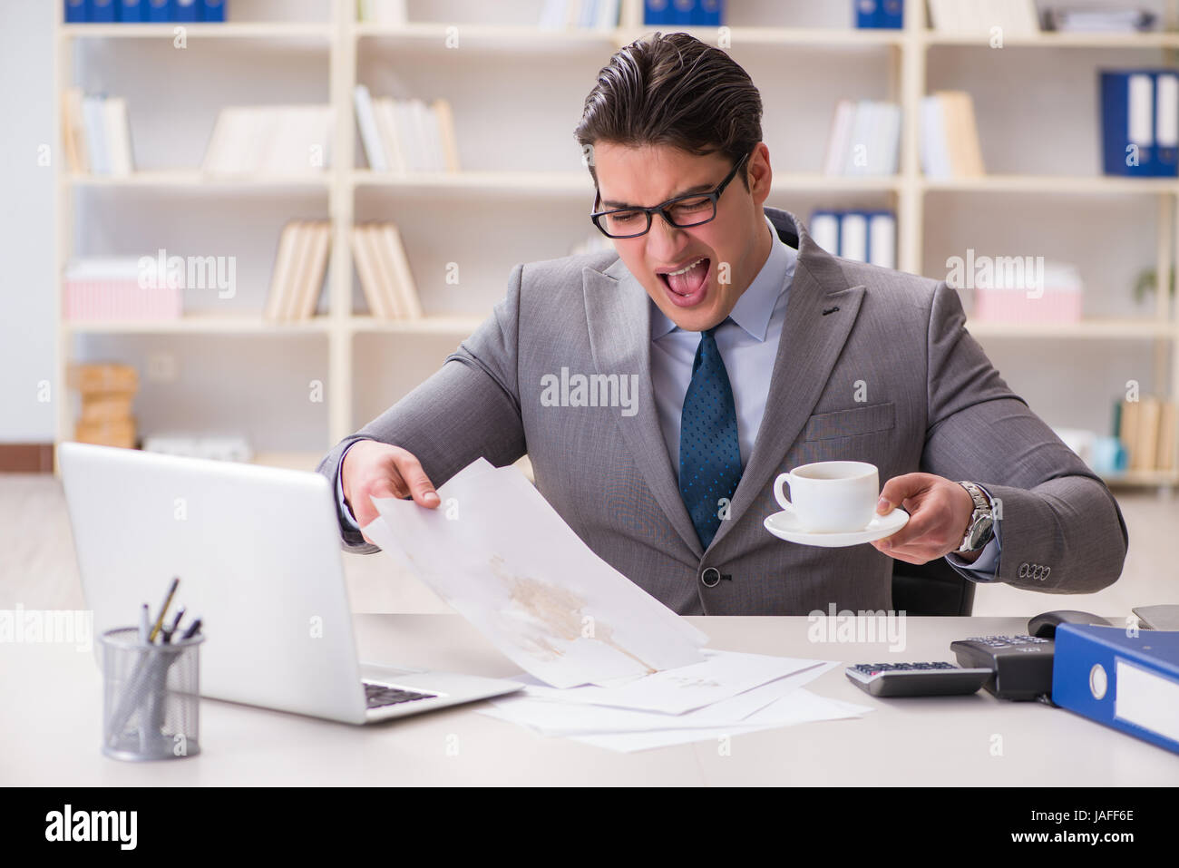 Businessman de renverser du café sur des documents importants Banque D'Images Businessman de renverser du café sur des documents importants Banque D'Images