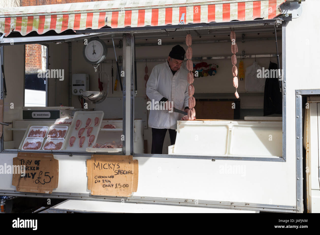 Le centre-ville d'Ashford stand affichage de la viande fraîche homme butcher couper la viande. Ashford, Kent Banque D'Images