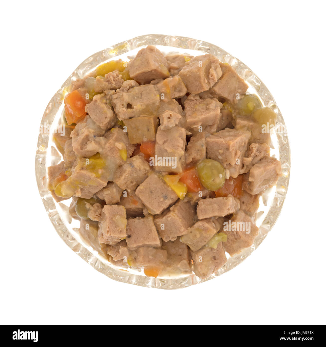 Vue de dessus d'un petit bol en verre rempli de nourriture pour chien d'agneau avec des petits pois et des courges isolé sur un fond blanc. Banque D'Images