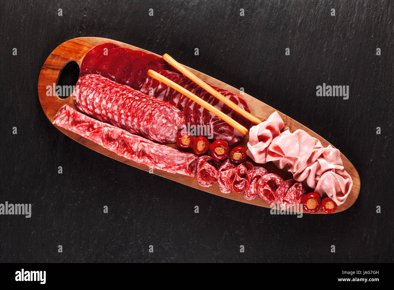 Grand plateau apéritif en bois avec différentes variétés de charcuterie fumé italien sur une pierre sombre contexte Banque D'Images