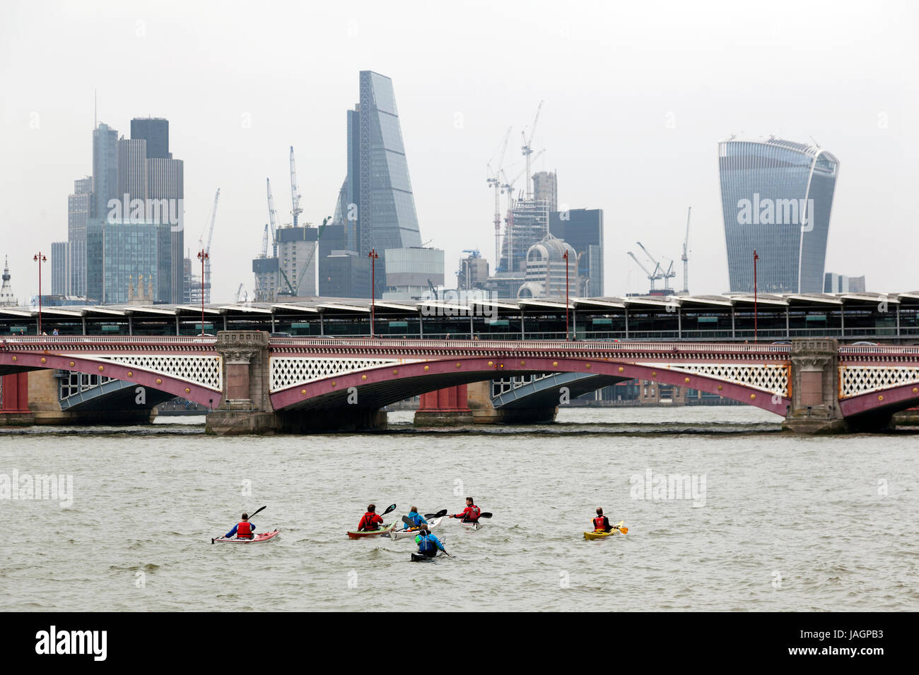 Londres, Royaume-Uni, 6 mai 2017 : canoë sur la Tamise à Londres regarder derrière les toits de la ville de London Blackfriars Bridge par temps nuageux en journée Banque D'Images