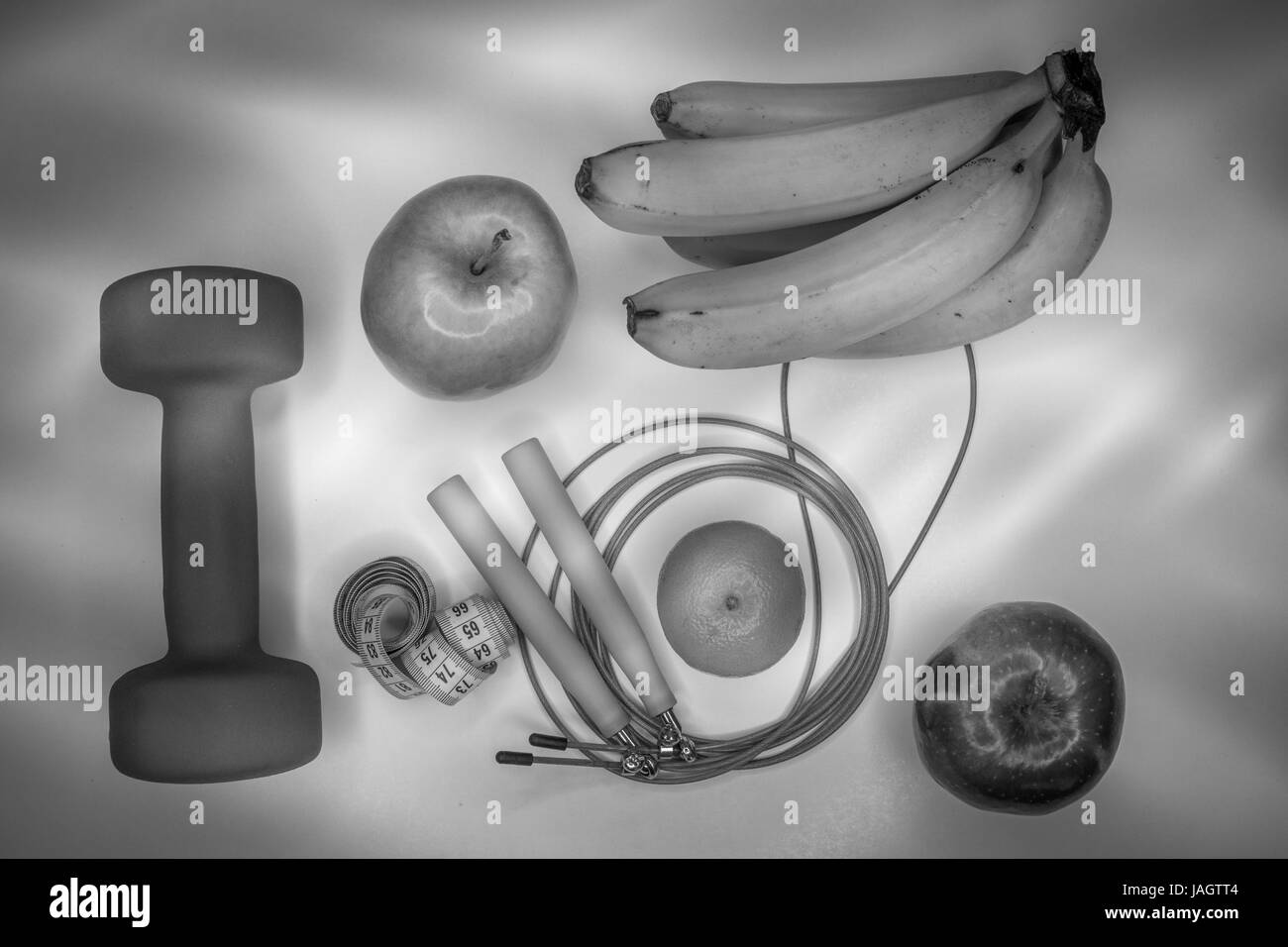 Concept de saine alimentation. Haltère, corde, banane, orange, ruban à mesurer la taille, des oranges, pomme rouge, pomme verte, sur un tableau blanc. mode de vie sain. le sport. Régime alimentaire de remise en forme. Concept en noir et blanc. Banque D'Images
