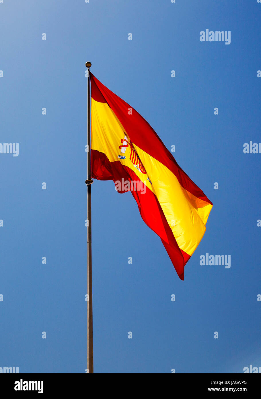 Le drapeau espagnol (Bandera de España, familièrement connu comme 'la Rojigualda") vole contre un ciel bleu profond. Banque D'Images