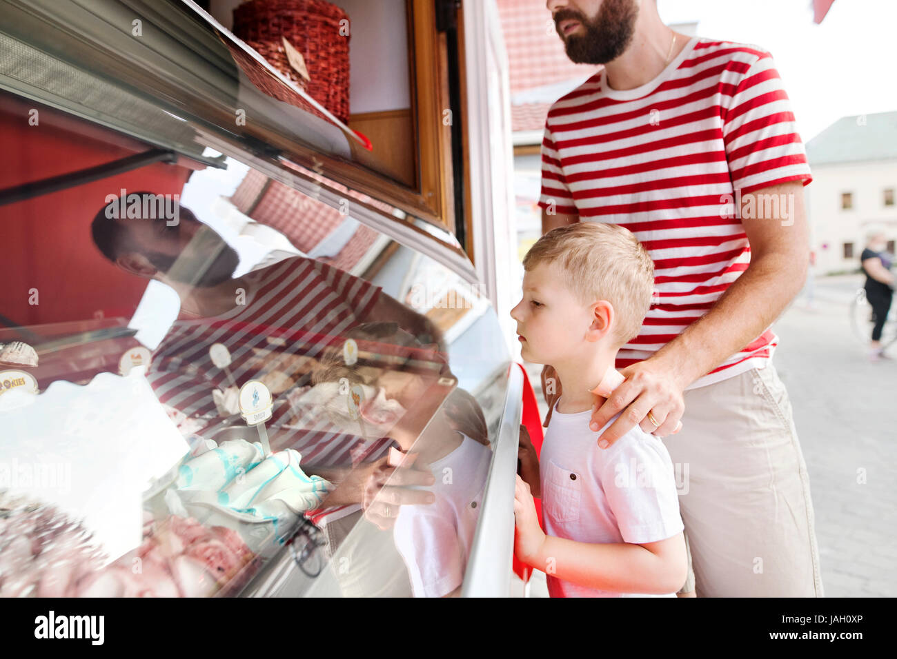 Jeune père et son petit-fils d'acheter de la crème glacée. Journée ensoleillée. Banque D'Images