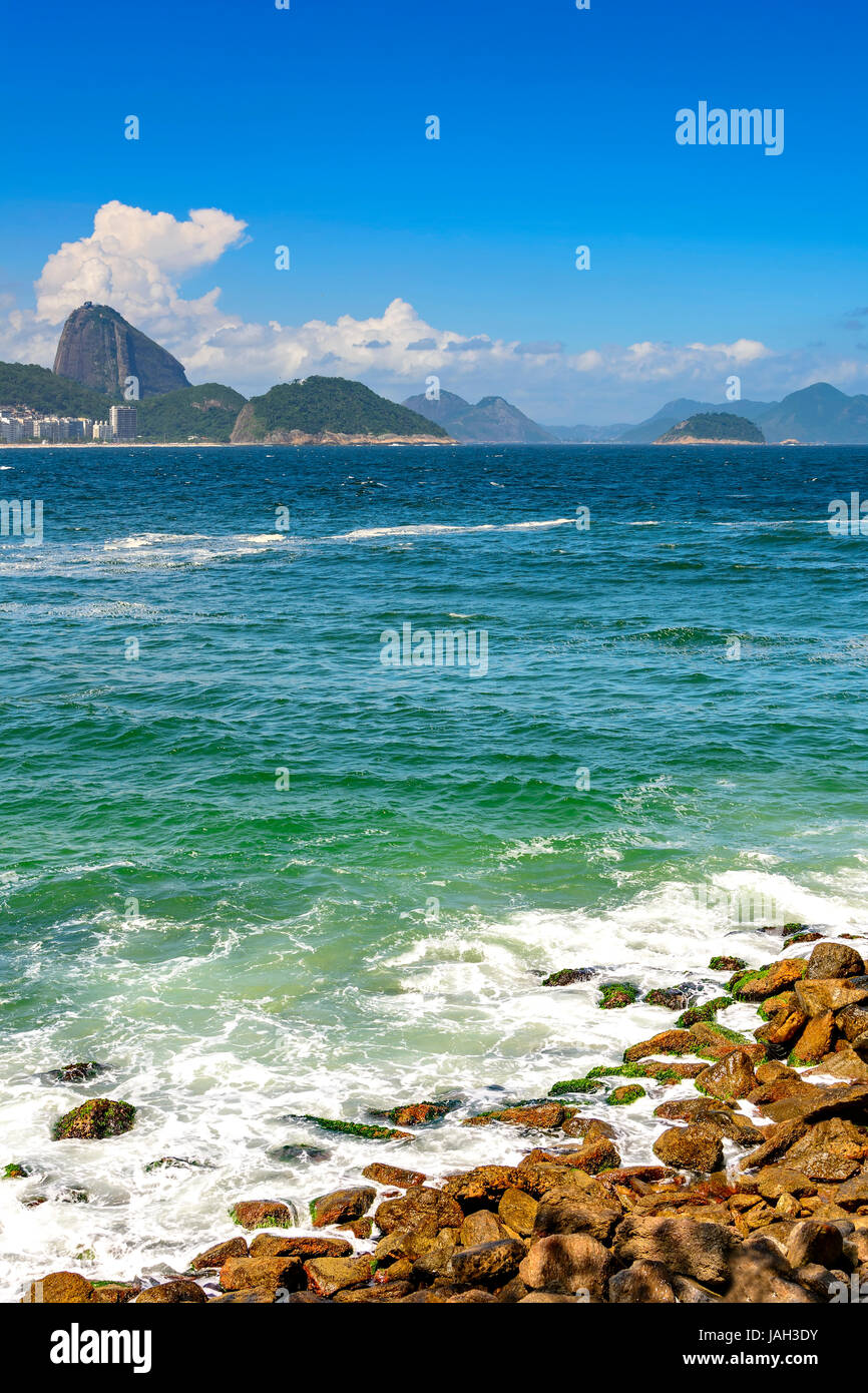 La plage de Copacabana à Rio de Janeiro avec ses immeubles, la mer, le sable et le Pain de Sucre Hill dans l'arrière-plan Banque D'Images