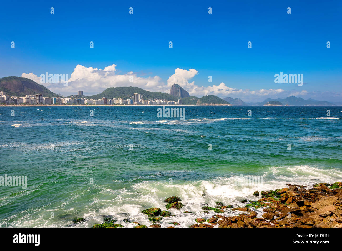 La plage de Copacabana à Rio de Janeiro avec ses immeubles, la mer, le sable et le Pain de Sucre Hill dans l'arrière-plan Banque D'Images