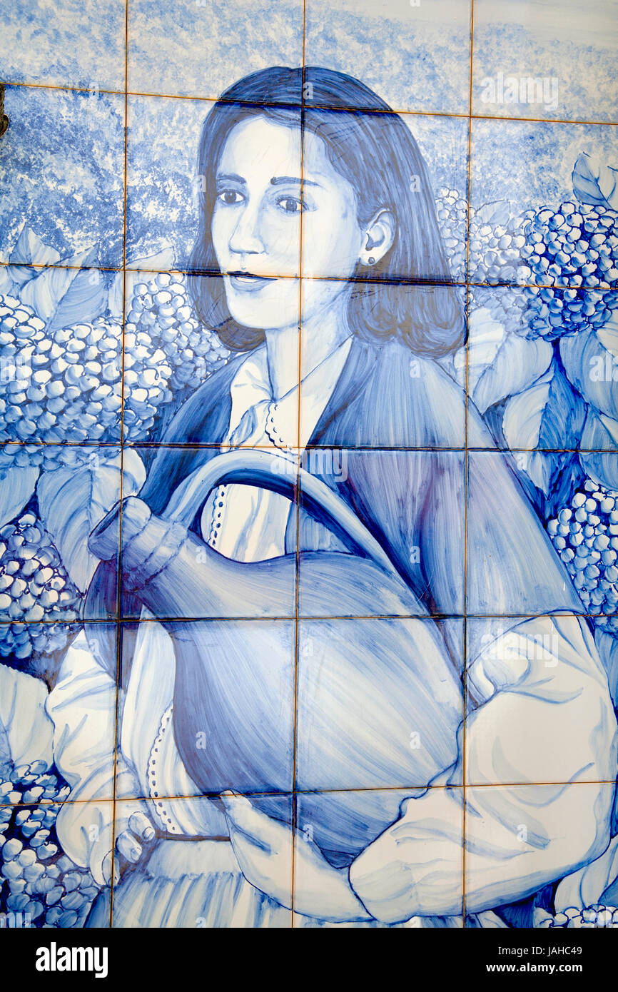 Une fresque en carreaux de faïence bleue, 'azulejo', avec l'image de jeune femme portant un pot. Vila Franca do Campo, Açores, Portugal. Banque D'Images