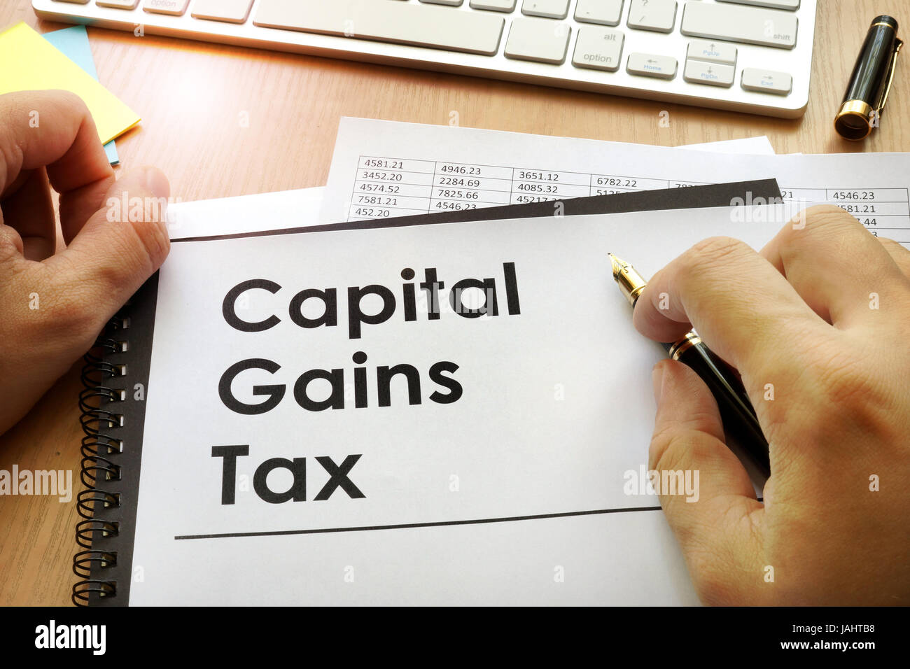 Mains tenant des documents avec l'impôt sur les gains en capital titre TBC. Banque D'Images