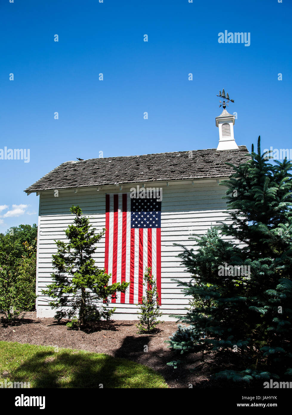 Drapeau américain sur une ancienne grange blanche restaurée avec une coupole ajoutée sur une ferme dans le comté de Cape May, New Jersey, Etats-Unis, Amérique rurale 2017 hangar de stockage pt Banque D'Images