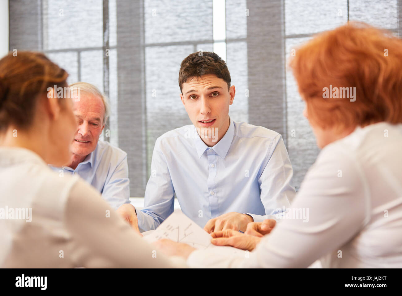 Jeune homme d'affaires ou étudiant en réunion avec des collègues qui travaillent dans l'esprit d'équipe Banque D'Images
