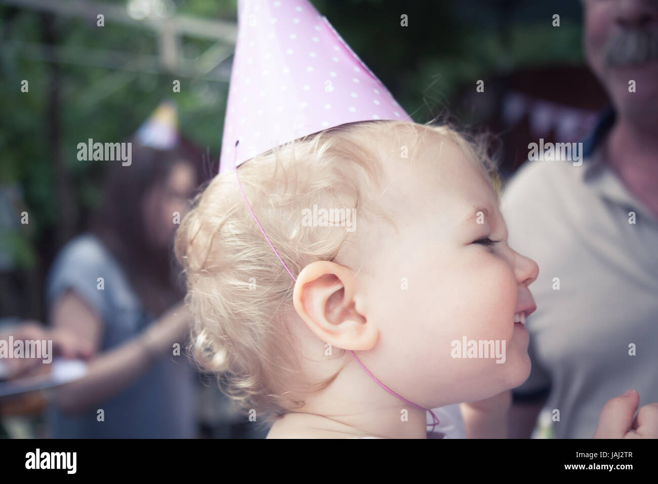 Funny cute baby girl joyeux anniversaire au cap smiling during Birthday party Banque D'Images