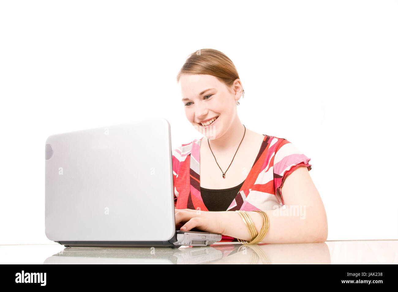Mädchen, Schülerin sitzt am Schreibtisch und arbeitet suis coffre vor weißem Hintergrund. Banque D'Images