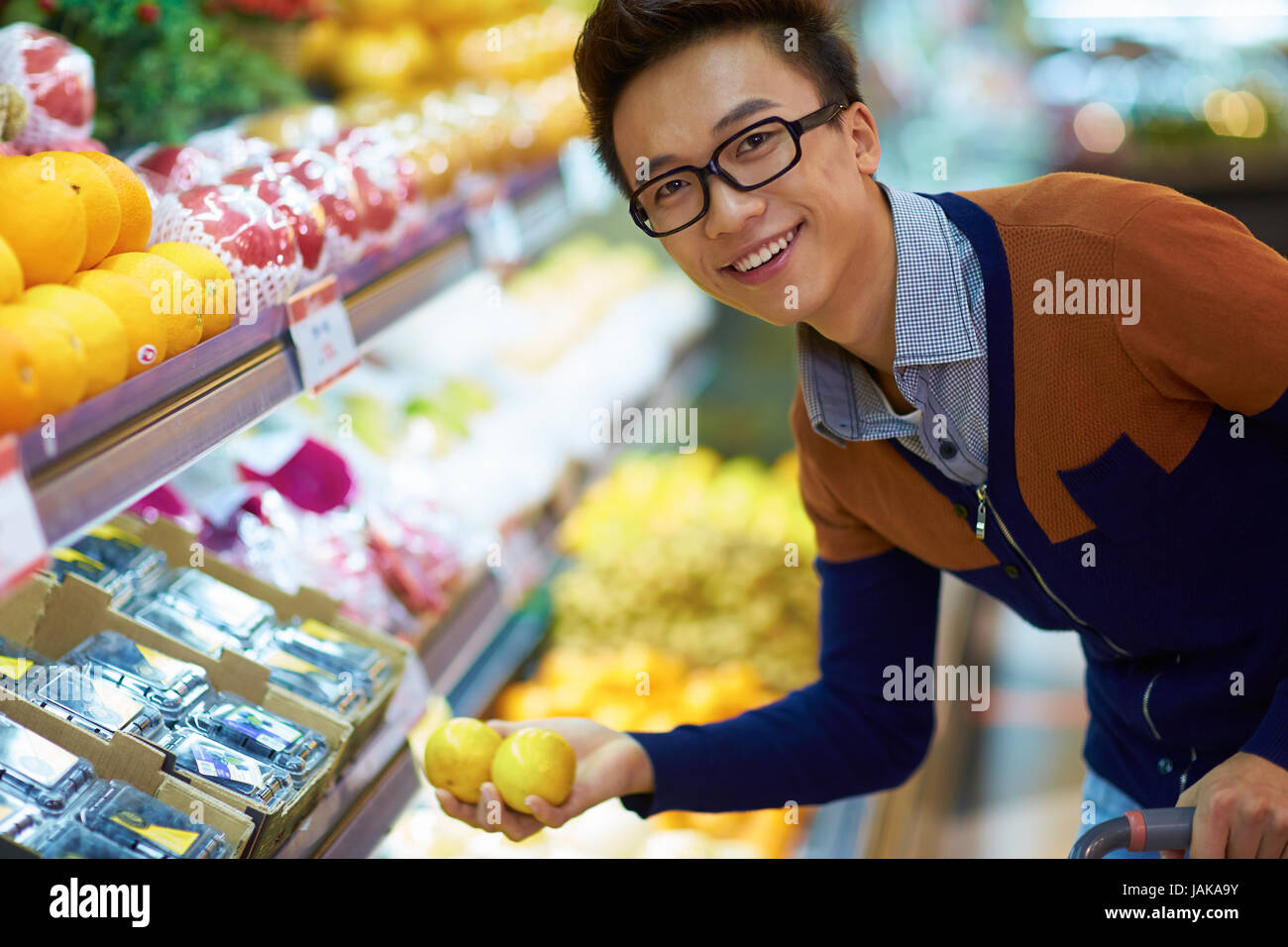 Un jeune homme d'origine chinoise d'acheter des fruits sur le marché Banque D'Images