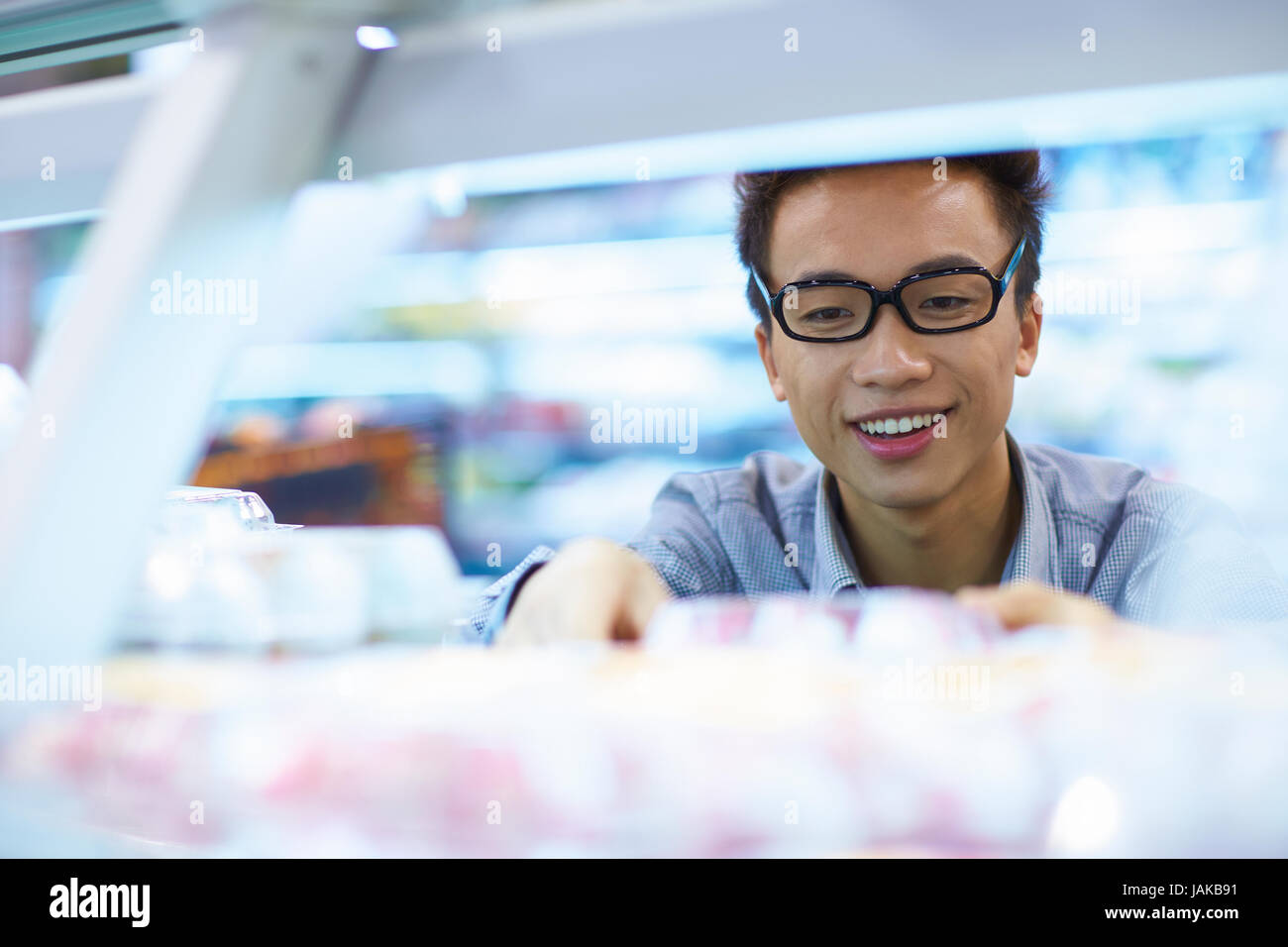 Un jeune homme d'origine chinoise d'acheter des fruits sur le marché Banque D'Images