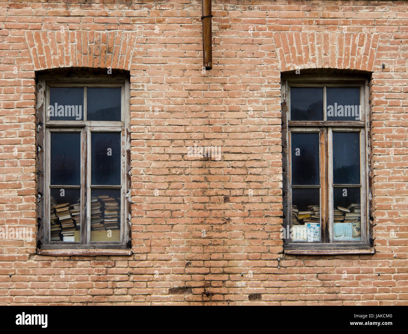 Vieux bâtiment en briques rouges de la façade, fenêtres en bois avec des piles de vieux livres jaunis, la ville en Azerbaïdjan Sheki Banque D'Images