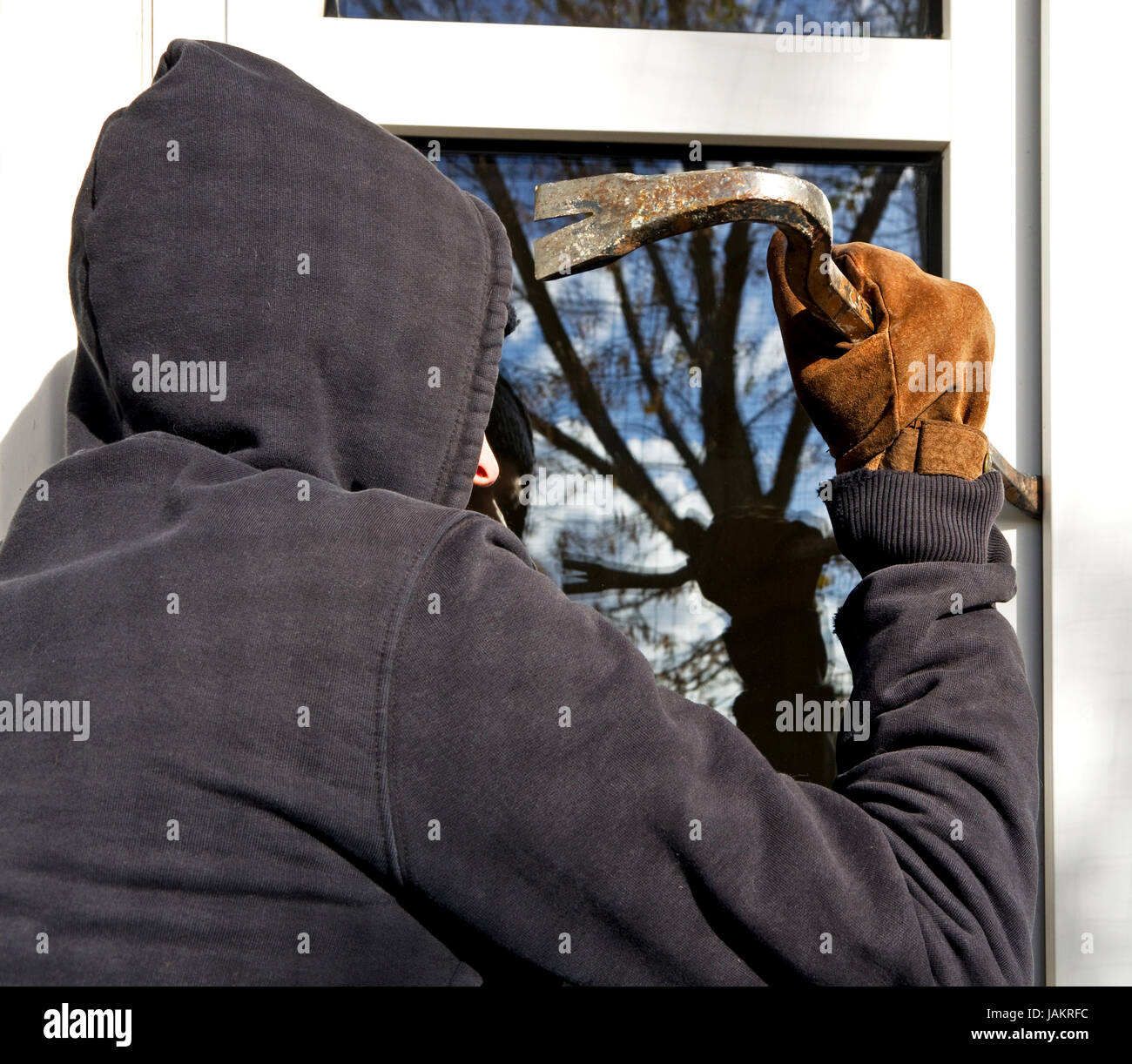 Housebraker avec l'outil essayant d'ouvrir la vitre Banque D'Images