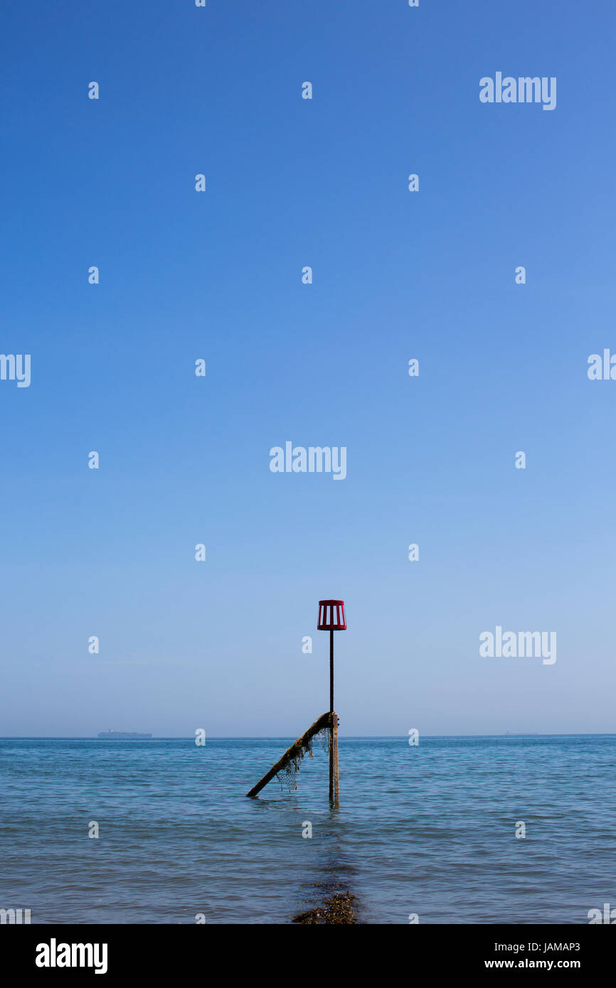 Un marqueur rouge à la fin d'un épi sur la plage de Sandown, Isle of Wight, sur une journée ensoleillée. Banque D'Images
